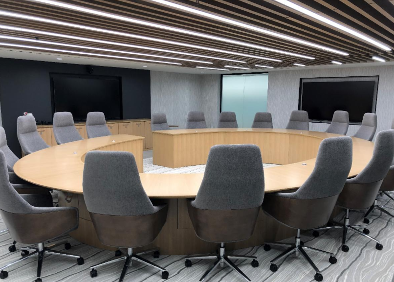 Large circular board meeting table with sixteen chairs