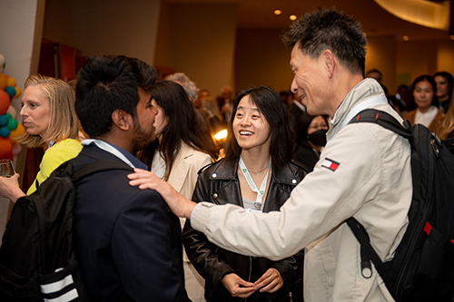 Group of colleagues talking in a crowded room.